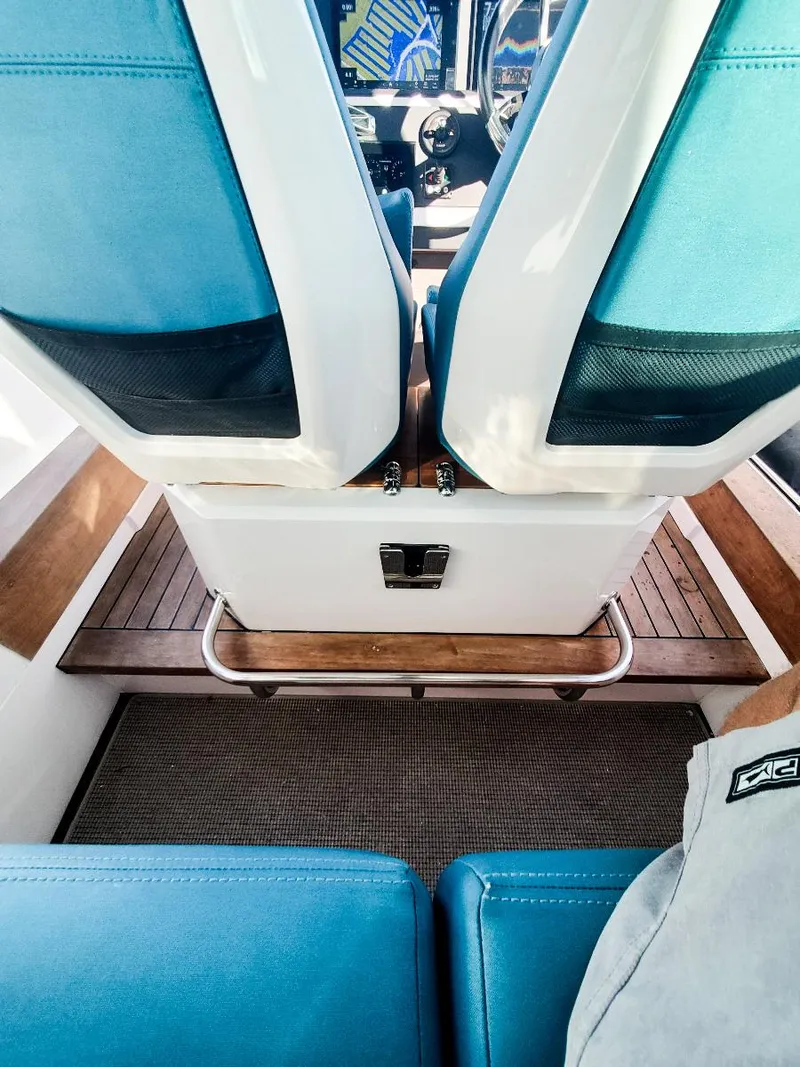 Slide: The Image of Interior view of 2021 Axopar 28 CABIN with blue seats and wooden flooring. - 14