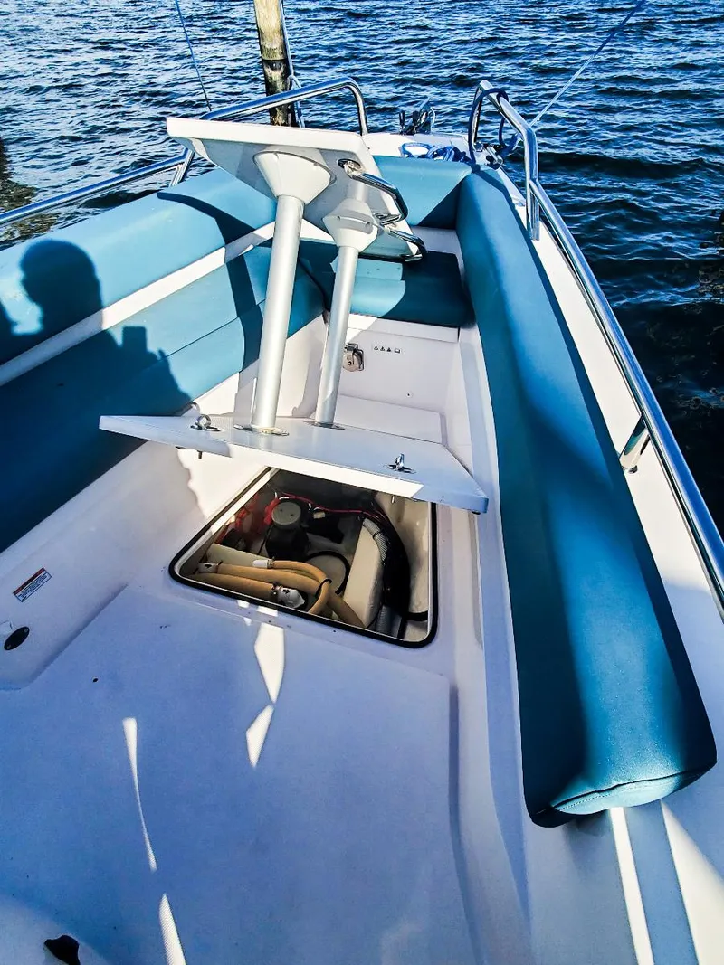 Slide: The Image of 2021 Axopar 28 CABIN boat interior with blue seating and open storage compartment. - 20