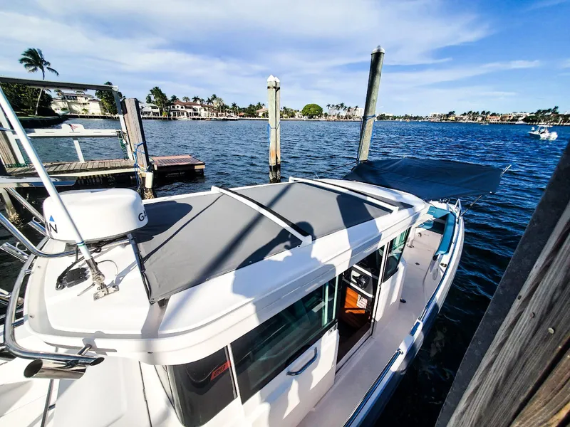 Slide: The Image of 2021 Axopar 28 CABIN boat docked by a scenic waterfront. - 8