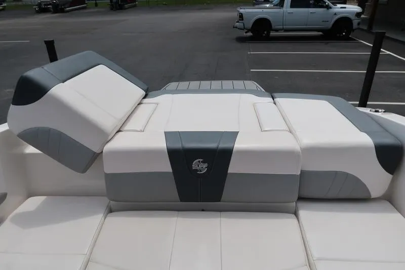 Slide: The Image of 2020 Chaparral 21 Surf boat interior with cushioned seating in a parking lot. - 11