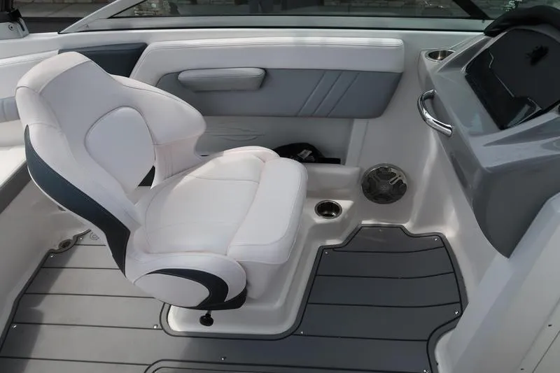 Slide: The Image of 2020 Chaparral 21 Surf boat interior with white captain's chair and gray flooring. - 18