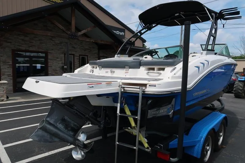 Slide: The Image of 2020 Chaparral 21 Surf boat on trailer, parked outside a building. - 2