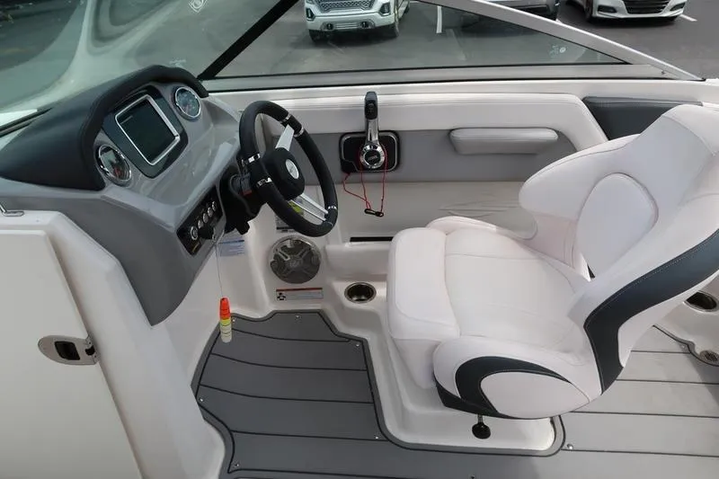 Slide: The Image of 2020 Chaparral 21 Surf boat interior with steering wheel and white captain's chair. - 21