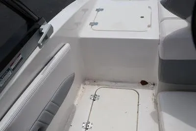 Slide: The Image of 2020 Chaparral 21 Surf boat interior with white seating and storage compartments. - 9