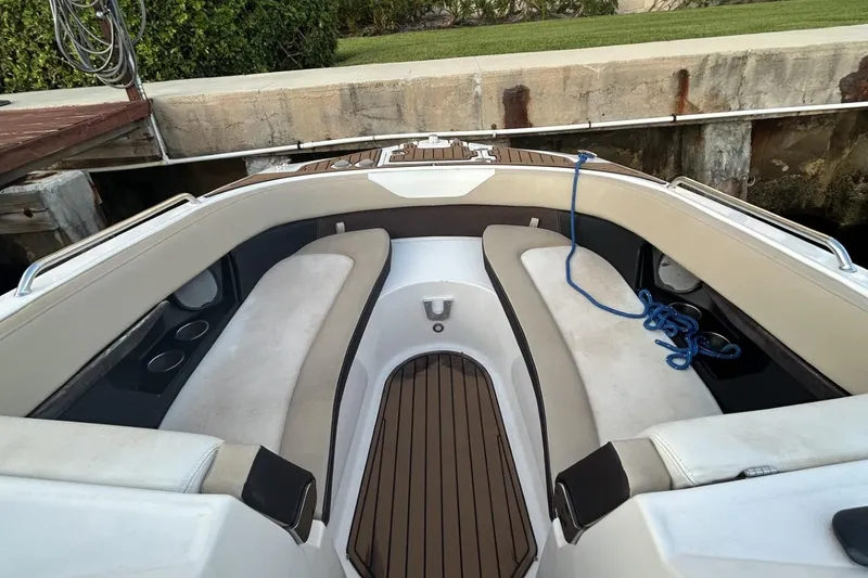 Slide: The Image of 2015 Regal 27 FasDeck boat interior with cushioned seating and wooden flooring. - 11