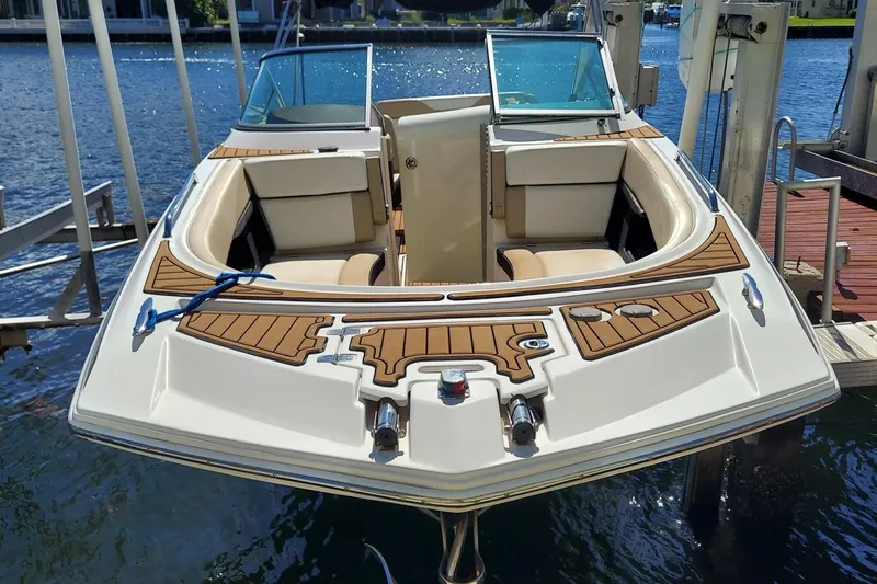Slide: The Image of 2015 Regal 27 FasDeck boat docked, featuring spacious seating and elegant wood accents. - 15