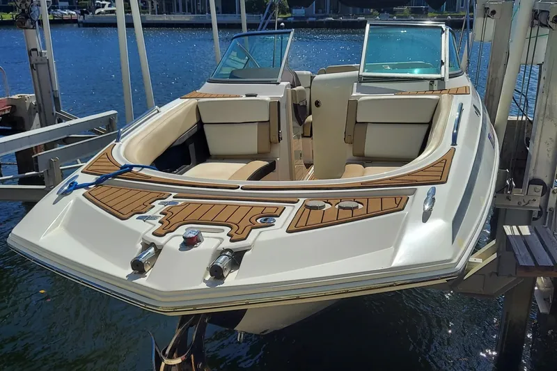 Slide: The Image of 2015 Regal 27 FasDeck boat on lift, featuring sleek design and spacious seating. - 17