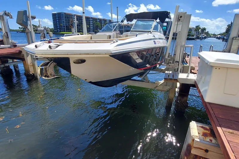 Slide: The Image of 2015 Regal 27 FasDeck boat on lift at marina, sunny day, waterfront view. - 18