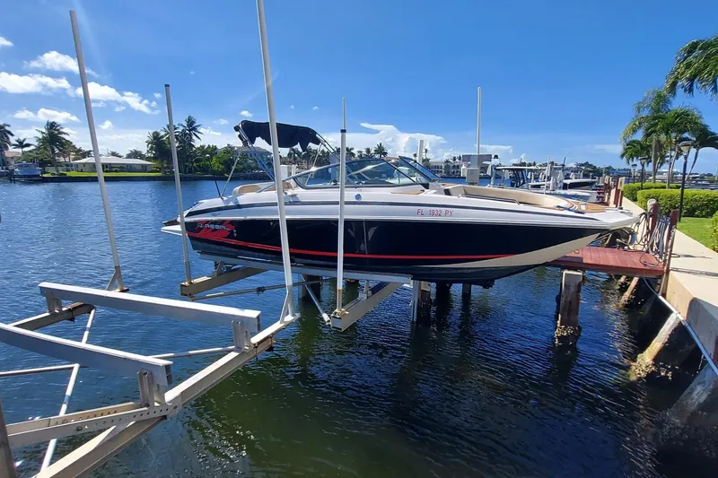 Slide: The Image of 2015 Regal 27 FasDeck boat docked on a sunny waterfront with palm trees. - 24