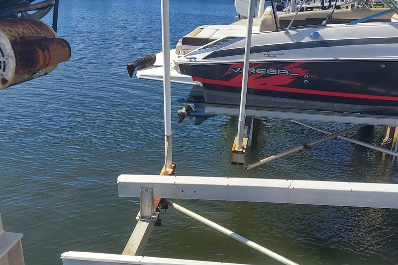 Slide: The Image of 2015 Regal 27 FasDeck boat on lift over water at marina. - 25