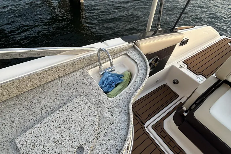 Slide: The Image of 2015 Regal 27 FasDeck boat interior with sink and seating area. - 4