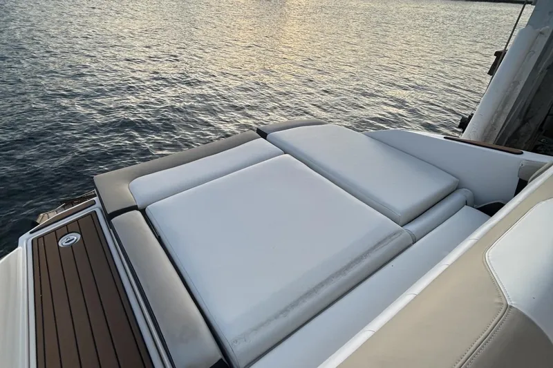 Slide: The Image of 2015 Regal 27 FasDeck boat with cushioned sun deck by the water. - 6