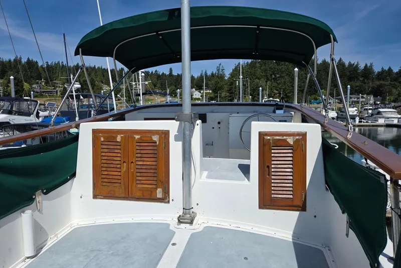 Slide: The Image of 1973 Willard Marine Vega Nomad Flybridge with green canopy, docked in a marina. - 15