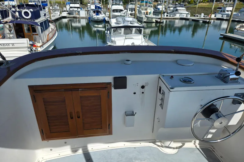 Slide: The Image of 1973 Willard Marine Vega Nomad Flybridge helm with wooden cabinet, docked in marina. - 17