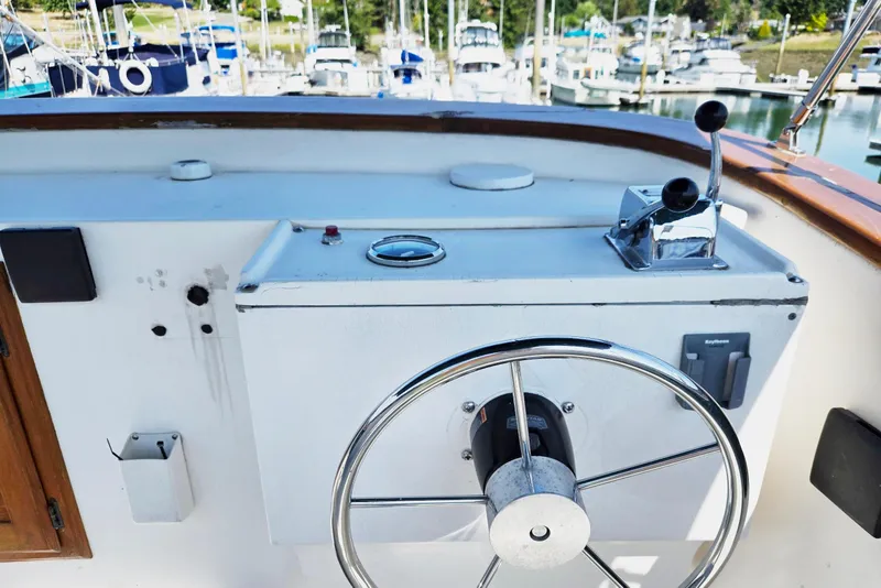 Slide: The Image of 1973 Willard Marine Vega Nomad Flybridge helm with steering wheel and controls, docked at marina. - 18