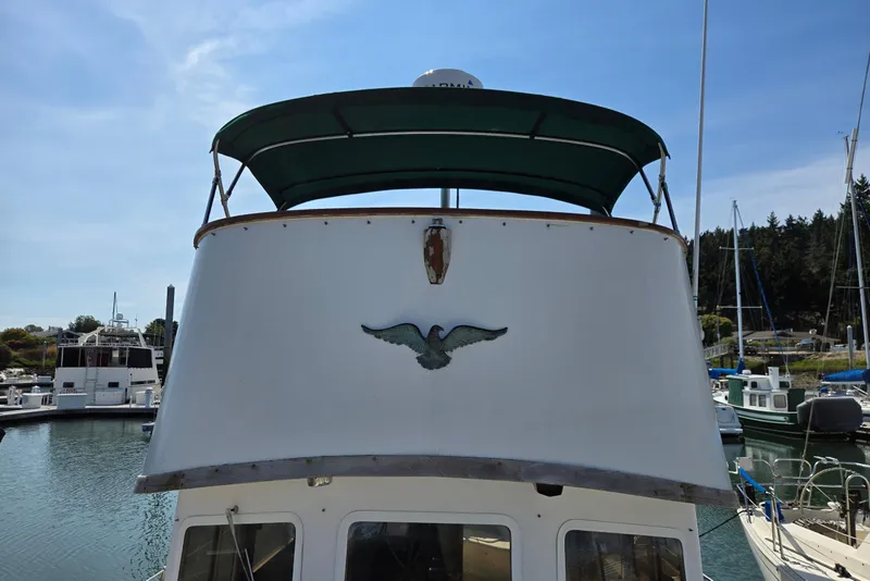 Slide: The Image of 1973 Willard Marine Vega Nomad Flybridge boat docked in a marina, featuring a green canopy. - 3