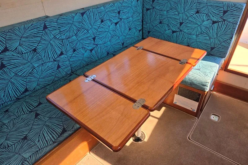 Slide: The Image of 1973 Willard Marine Vega Nomad Flybridge interior with foldable wooden table and patterned seating. - 37