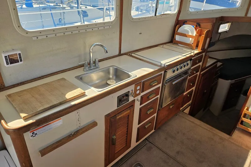 Slide: The Image of 1973 Willard Marine Vega Nomad Flybridge kitchen with sink, stove, and wooden cabinetry. - 39