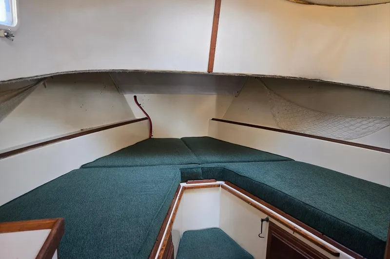 Slide: The Image of 1973 Willard Marine Vega Nomad Flybridge cabin interior with green cushions and storage netting. - 42