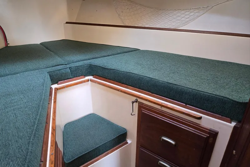Slide: The Image of Interior cabin of 1973 Willard Marine Vega Nomad Flybridge with green cushions and wooden storage. - 44