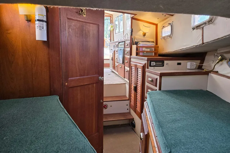 Slide: The Image of Interior of 1973 Willard Marine Vega Nomad Flybridge with wooden cabinetry and twin beds. - 46