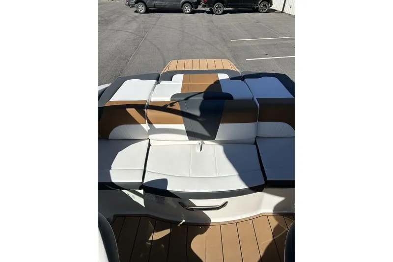 Slide: The Image of 2026 Chaparral 21 SSi boat with stylish brown and white seating in a parking lot. - 12