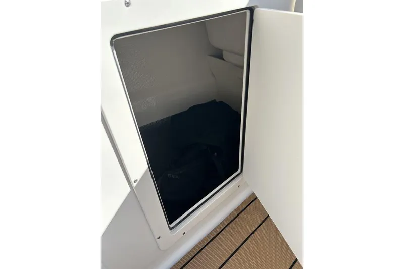 Slide: The Image of Open storage compartment on 2026 Chaparral 21 SSi boat, featuring sleek interior design. - 14