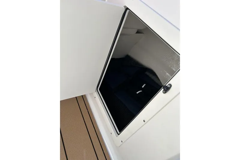 Slide: The Image of 2026 Chaparral 21 SSi boat storage compartment with open door, revealing interior space. - 16