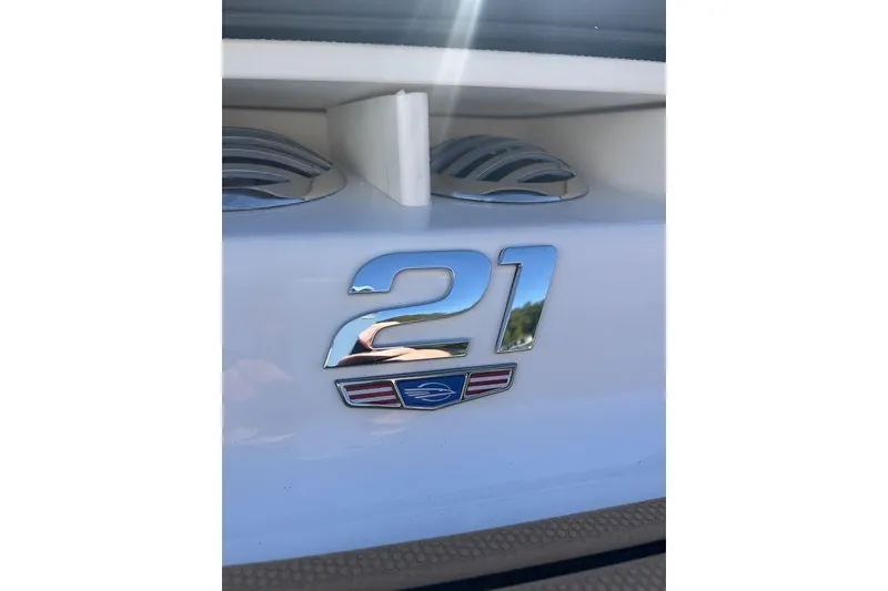 Slide: The Image of 2026 Chaparral 21 SSi boat emblem with chrome finish and decorative accents. - 2