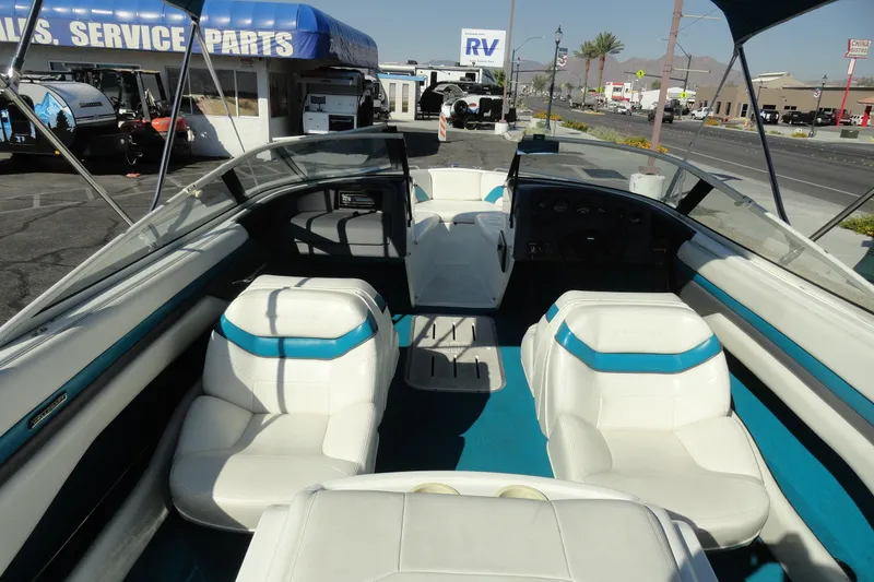 Slide: The Image of 1995 Wellcraft Eclipse 196 S boat interior with white and blue seating, parked near service area. - 6