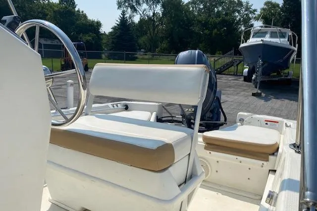 Slide: The Image of 2015 Triumph 170 CC boat interior with steering wheel and seating, parked outdoors. - 4