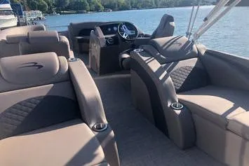 Slide: The Image of 2019 Bennington 22 SCWXP pontoon boat interior with plush seating on a sunny lake. - 20