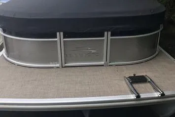 Slide: The Image of 2019 Bennington 22 SCWXP pontoon boat with covered seating area and ladder. - 21
