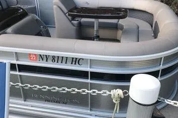 Slide: The Image of 2019 Bennington 22 SCWXP pontoon boat docked, featuring plush seating and sleek design. - 28