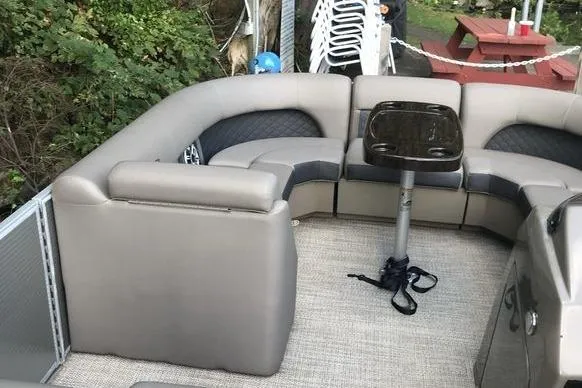 Slide: The Image of 2019 Bennington 22 SCWXP pontoon boat interior with gray seating and a small table. - 3