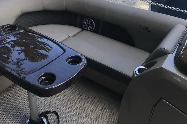Slide: The Image of 2019 Bennington 22 SCWXP boat interior with cushioned seating and a table with cup holders. - 6