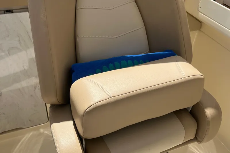 Slide: The Image of 2024 Scout 240 Dorado boat seat with beige upholstery and blue towel. - 11