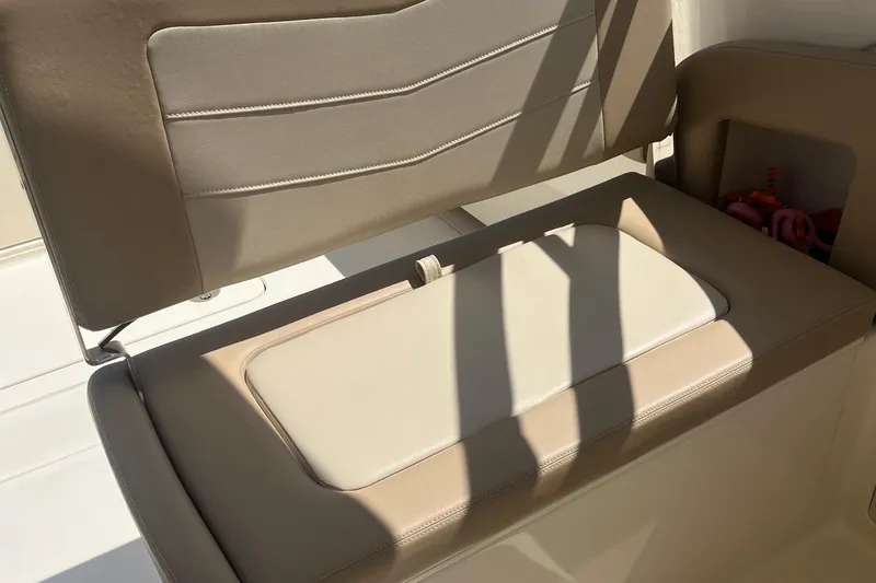Slide: The Image of 2024 Scout 240 Dorado boat seat with beige upholstery and storage compartment. - 12