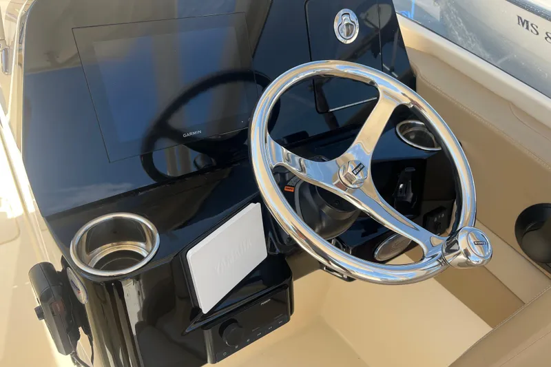 Slide: The Image of 2024 Scout 240 Dorado boat dashboard with steering wheel and Garmin display. - 14