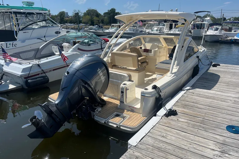 Slide: The Image of 2024 Scout 240 Dorado boat docked, featuring Yamaha outboard motor, in a marina setting. - 6