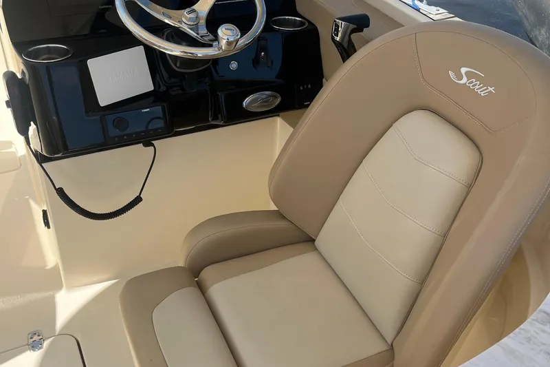 Slide: The Image of 2024 Scout 240 Dorado boat interior with steering wheel and beige seating. - 9