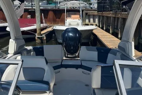 Slide: The Image of 2019 Chaparral 250 Suncoast boat docked, featuring spacious seating and sleek design. - 16