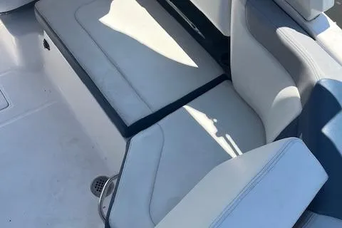 Slide: The Image of 2019 Chaparral 250 Suncoast boat interior seating, featuring white and blue upholstery. - 8