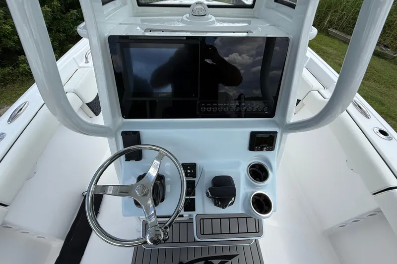 Slide: The Image of 2026 Tidewater 232 LXF boat console with steering wheel and navigation display. - 15