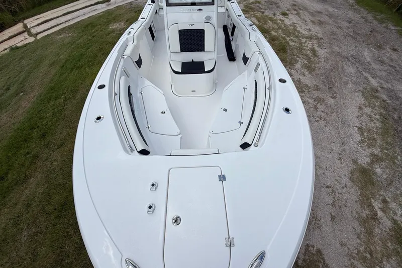 Slide: The Image of 2026 Tidewater 232 LXF boat, white interior, spacious seating, sleek design, parked on grass. - 17