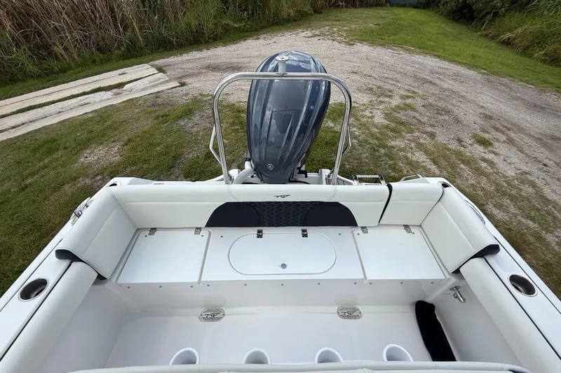 Slide: The Image of 2026 Tidewater 232 LXF boat interior with outboard motor, white seating, and storage compartments. - 23