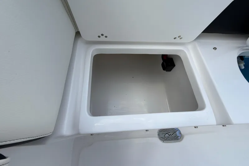 Slide: The Image of Storage compartment of 2026 Tidewater 232 LXF boat, featuring sleek white interior. - 25