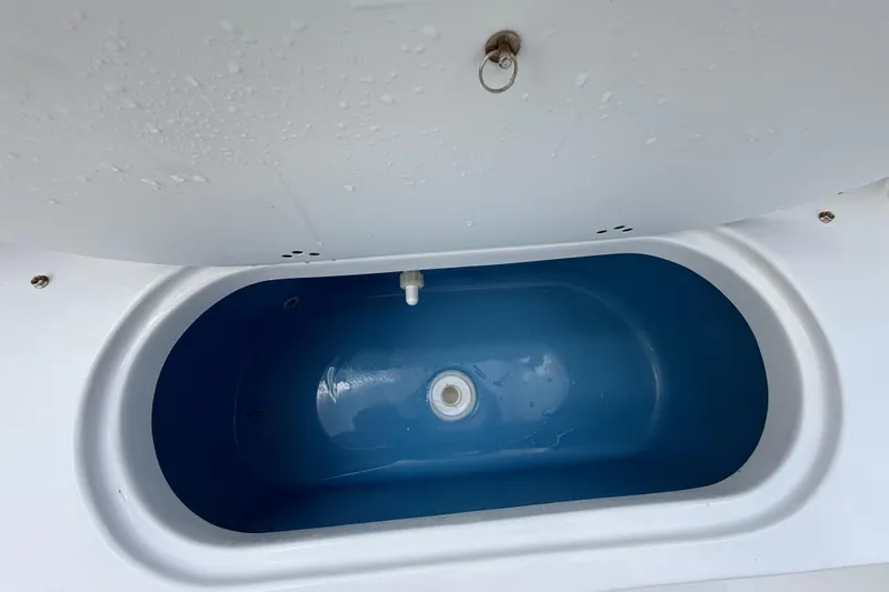 Slide: The Image of Livewell compartment on a 2026 Tidewater 232 LXF boat, featuring a blue interior. - 26