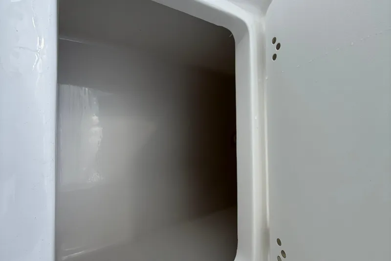Slide: The Image of Storage compartment of 2026 Tidewater 232 LXF boat, featuring a sleek white interior. - 27