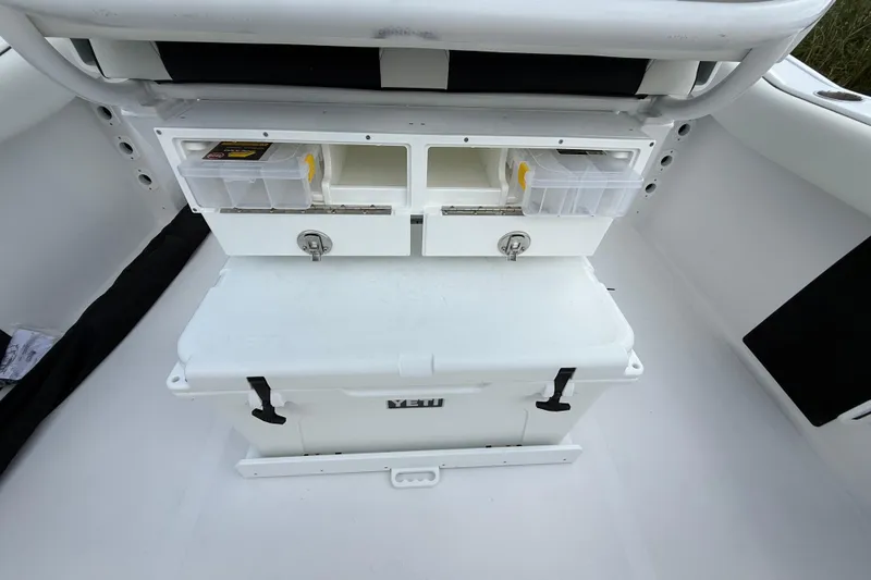 Slide: The Image of 2026 Tidewater 232 LXF boat storage area with Yeti cooler and tackle boxes. - 29